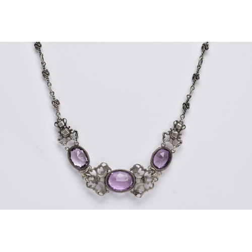 69 - AN ARTS AND CRAFTS AMETHYST NECKLACE, designed with three collet set, oval mix cut amethysts, inters... 
