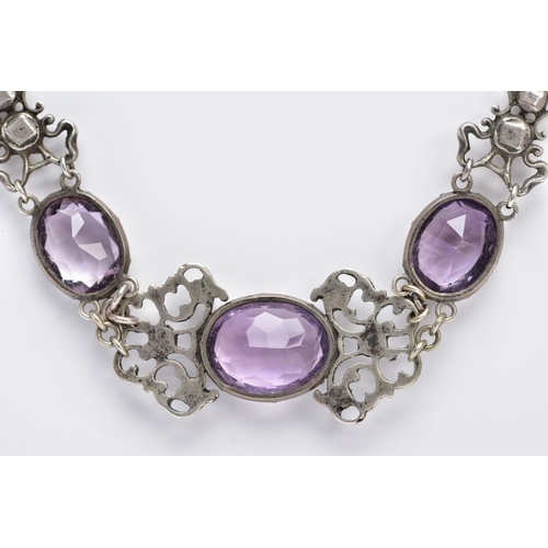 69 - AN ARTS AND CRAFTS AMETHYST NECKLACE, designed with three collet set, oval mix cut amethysts, inters... 