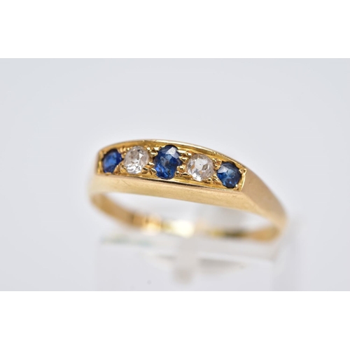 73 - AN 18CT GOLD FIVE STONE RING, of a boat shape, set with a central oval cut blue sapphire interspaced... 