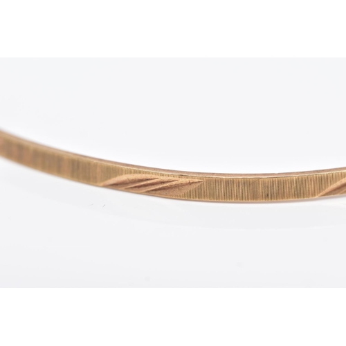 118 - A 9CT GOLD BANGLE, thin bangle with a textured and foliate engraved design, hallmarked 9ct gold Lond... 