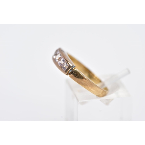 12 - A YELLOW METAL HALF HOOP RING, designed with a row of graduated square cut colourless stones, assess... 