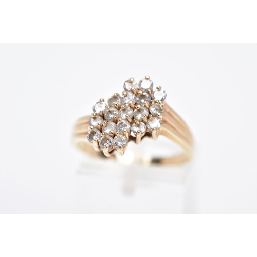 2 - A YELLOW METAL DIAMOND CLUSTER RING, an asymmetrical cluster design with claw set, round brilliant c... 