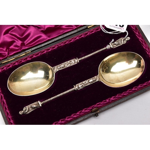 215 - A CASED TWO PIECE LATE VICTORIAN SILVER GILT SPOON SET, brown case opens to reveal a purple velvet a... 