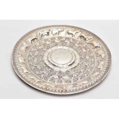 232 - AN INDIAN WHITE METAL PRESENTATION SALVER, embossed animal and foliate design, engraved to the centr... 