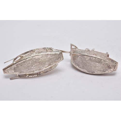 244 - TWO MODERN ORIENTAL, WHITE METAL FILIGREE BOAT ORNAMENTS, one with a standing figure with paddle, ap... 