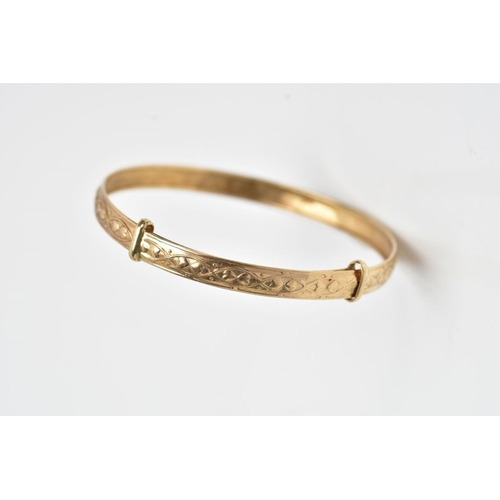 251 - A 9CT GOLD CHRISTENING BANGLE, embossed heart and scroll design, hallmarked 9ct gold Birmingham, app... 