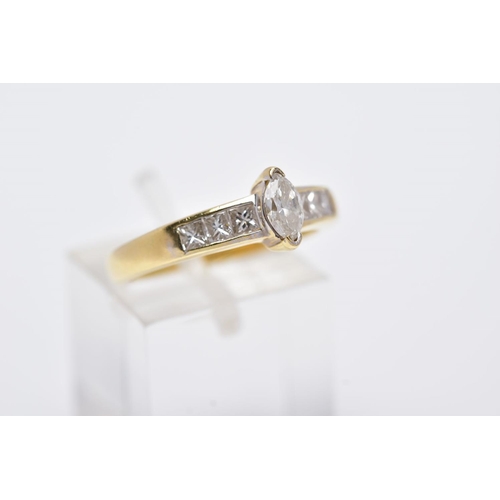 27 - A YELLOW METAL DIAMOND RING, designed with a central raised, marquise cut diamond, flanked with prin... 