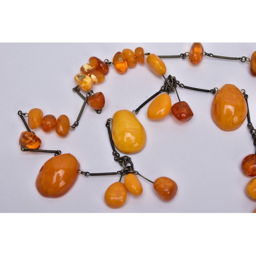 40 - AN AMBER NECKLACE, designed with a mixture of transparent and butterscotch coloured amber in various... 