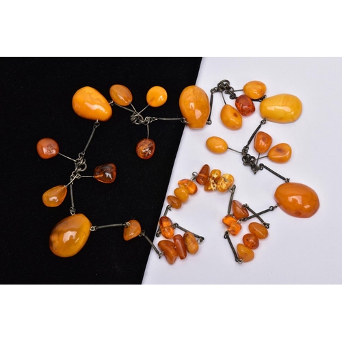 40 - AN AMBER NECKLACE, designed with a mixture of transparent and butterscotch coloured amber in various... 