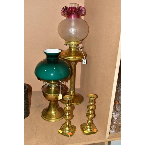 426 - A TWIN BURNER BRASS OIL LAMP HAVING ETCHED GLASS WITH CRANBERRY GLASS FRILLED SHADE, including chimn... 