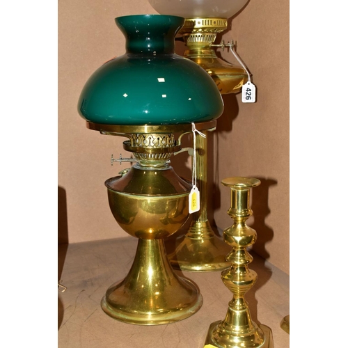 426 - A TWIN BURNER BRASS OIL LAMP HAVING ETCHED GLASS WITH CRANBERRY GLASS FRILLED SHADE, including chimn... 