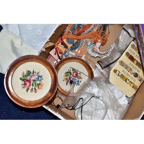 438 - A BOX OF WOOLWORK, including three framed completed floral woolworks, a woolwork instruction pattern... 