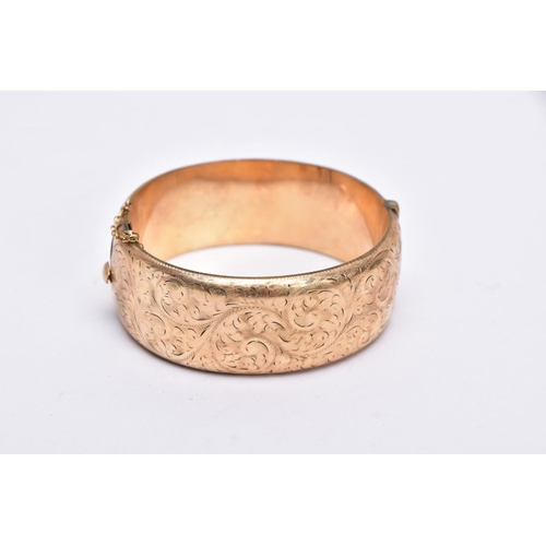 46 - A ROLLED GOLD WIDE BANGLE, hinged bangle with a half engraved foliate design, push pin clasp, fitted... 