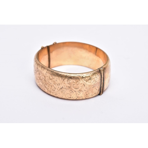 46 - A ROLLED GOLD WIDE BANGLE, hinged bangle with a half engraved foliate design, push pin clasp, fitted... 