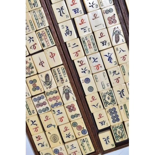 573 - A LATE 19TH/EARLY 20TH CENTURY MAH JONG SET, the bone and bamboo playing pieces housed in a relief c... 