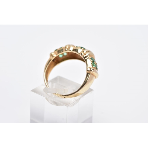 84 - A 14CT GOLD EMERALD RING, designed with three sections each set with two rows of circular cut emeral... 