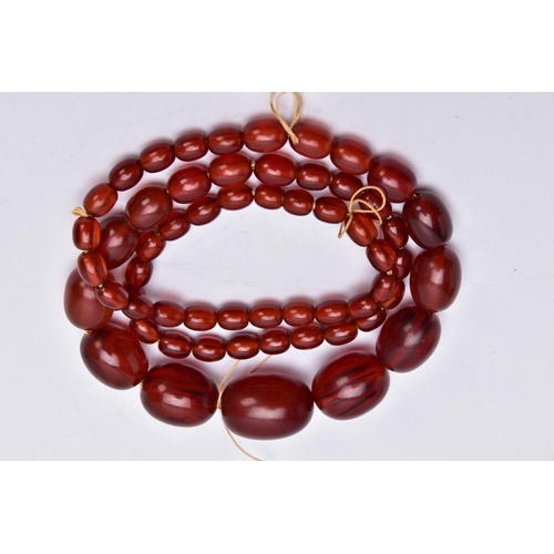 86 - A CHERRY AMBER STYLE BAKERLITE BEADED NECKLACE, graduated beads, largest bead measuring 28.4mm x 20.... 