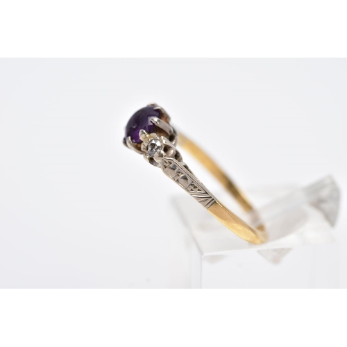 97 - A YELLOW METAL THREE STONE RING, design with a central circular cut purple stone, assessed as paste,... 