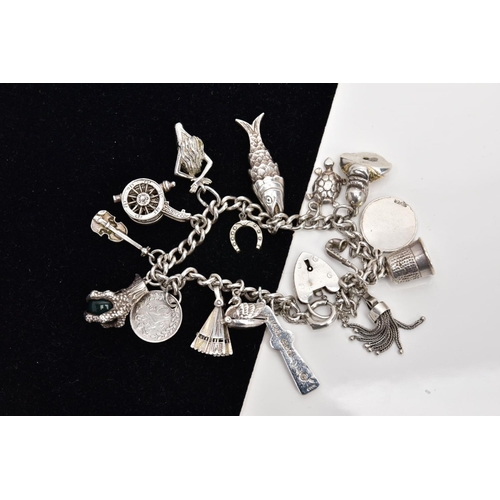 48 - A SILVER CHARM BRACELET, suspending sixteen charms in forms such as a claw holding a bloodstone ball... 