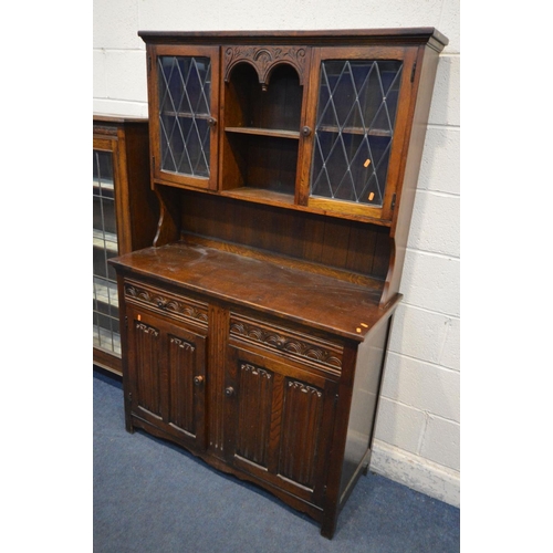 1209 - AN EARLY 20TH OAK LEAD GLAZED BOOKCASE, the double doors enclosing three adjustable shelves, on fron... 