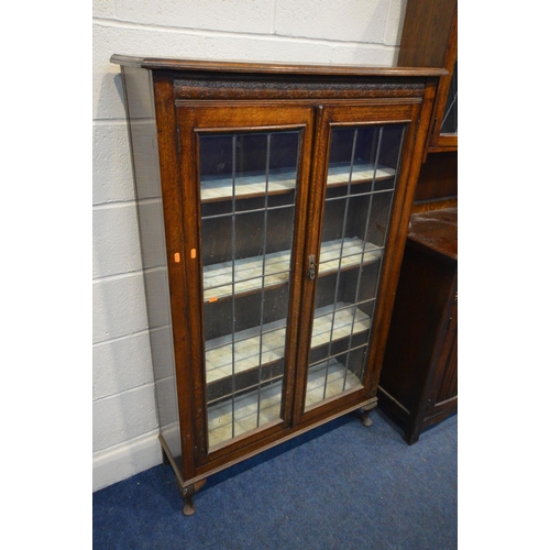 1209 - AN EARLY 20TH OAK LEAD GLAZED BOOKCASE, the double doors enclosing three adjustable shelves, on fron... 