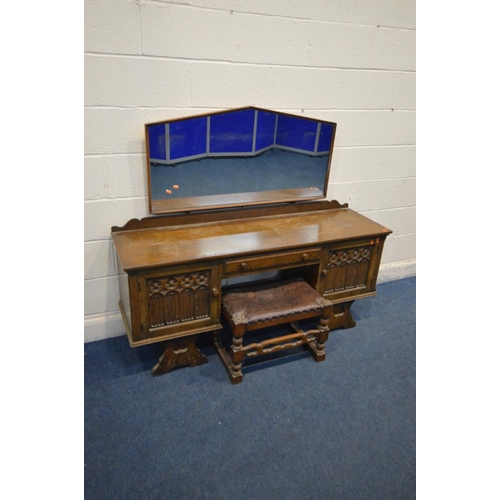 1212 - AN OAK GOTHIC DRESSING TABLE with a shaped mirror, two cupboard doors flanking a single drawer, widt... 