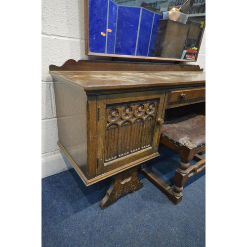 1212 - AN OAK GOTHIC DRESSING TABLE with a shaped mirror, two cupboard doors flanking a single drawer, widt... 