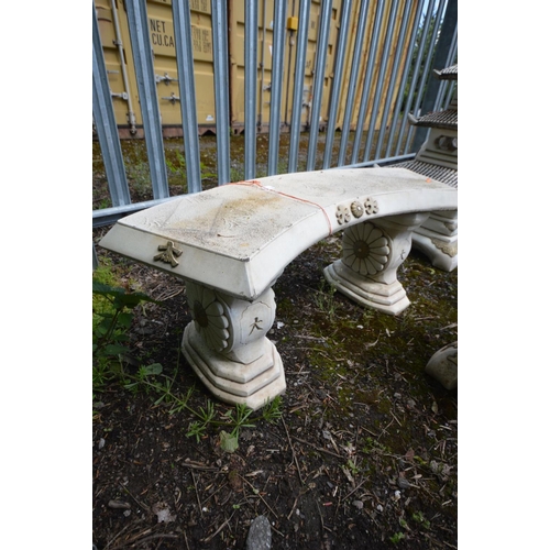 914 - A COMPOSITE JAPANESE CURVED GARDEN BENCH on a twin supports, length 112cm