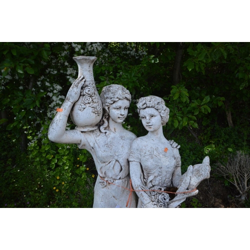 927 - A LARGE GARDEN FIGURE OF TWO FEMALES, in robes, one holding a vase aloft, the other holding flowers,... 