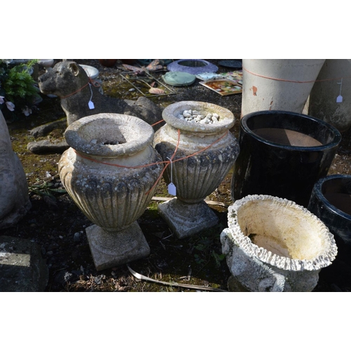 941 - A PAIR OF COMPOSITE URNS, height 42cm, along with two black glazed graduated plant pots, a small urn... 