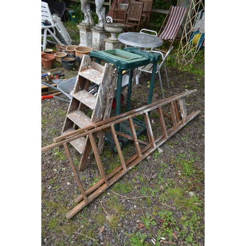 989 - A GALVANISED WHEELBARROW, containing a collection of garden hand tools, two wooden step ladders and ... 