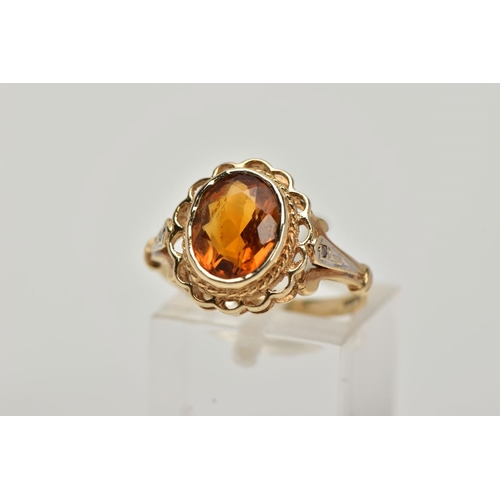 10 - A 9CT GOLD CITRINE AND DIAMOND RING, centring on a collet mounted oval cut citrine, openwork scallop... 