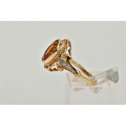 10 - A 9CT GOLD CITRINE AND DIAMOND RING, centring on a collet mounted oval cut citrine, openwork scallop... 