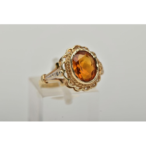 10 - A 9CT GOLD CITRINE AND DIAMOND RING, centring on a collet mounted oval cut citrine, openwork scallop... 