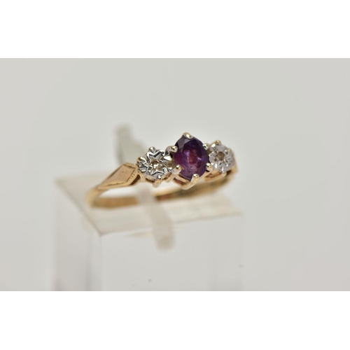 11 - A 9CT GOLD THREE STONE RING, centring on a claw set, oval cut amethyst, flanked with illusion set si... 