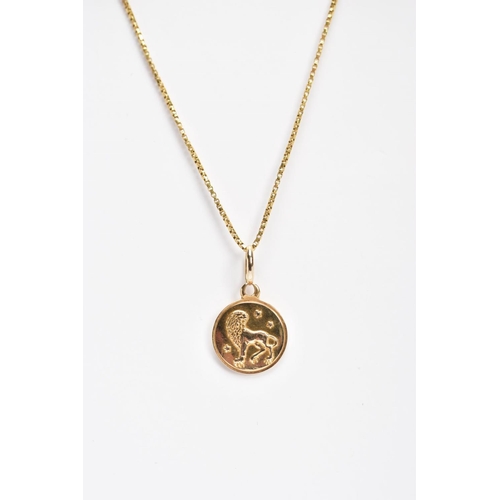 122 - A YELLOW METAL PENDANT NECKLACE, the pendant of a circular form with the zodiac lion sign 'Leo', app... 