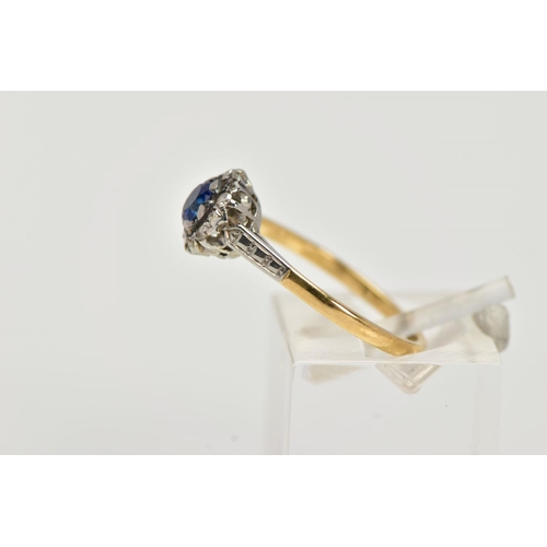 19 - A YELLOW METAL CLUSTER RING, designed with a central, circular cut blue sapphire within a surround o... 