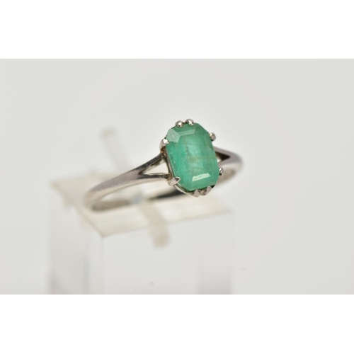 20 - A WHITE METAL EMERALD RING, centering on a claw set emerald, cut emerald approximate dimensions 8.2m... 