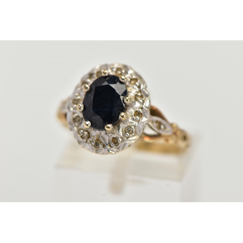 24 - A 9CT GOLD SAPPHIRE AND DIAMOND CLUSTER RING, raised cluster, centring on an oval cut blue sapphire,... 