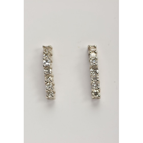 38 - A PAIR OF WHITE METAL DIAMOND DROP EARRINGS, each designed as a wavy line drop set with seven claw s... 