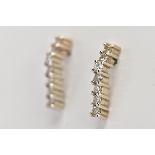 38 - A PAIR OF WHITE METAL DIAMOND DROP EARRINGS, each designed as a wavy line drop set with seven claw s... 