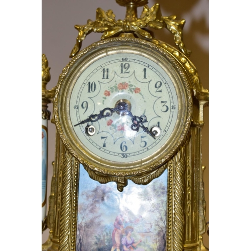 380 - A 20TH CENTURY BRASS AND PORCELAIN CLOCK GARNITURE, the porcelain panels transfer printed with coupl... 