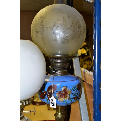 537 - FOUR BRASS BASED TWIN BURNER OIL LAMPS, one with a blue glass hand painted reservoir, the column mou... 