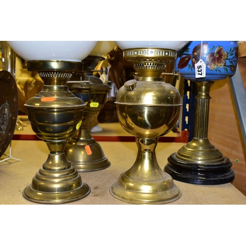 537 - FOUR BRASS BASED TWIN BURNER OIL LAMPS, one with a blue glass hand painted reservoir, the column mou... 