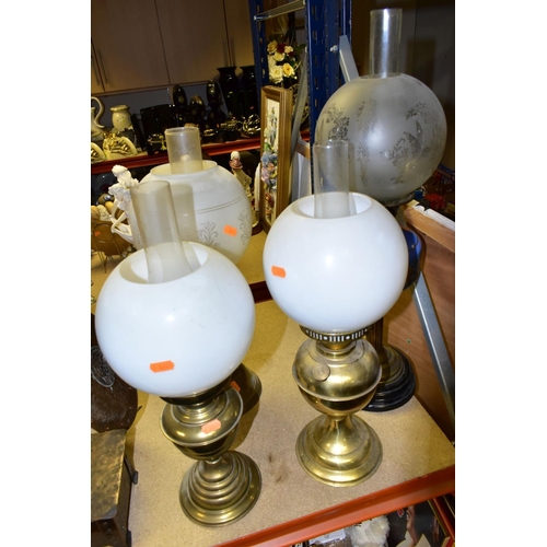 537 - FOUR BRASS BASED TWIN BURNER OIL LAMPS, one with a blue glass hand painted reservoir, the column mou... 