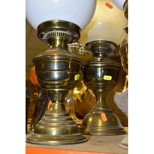 537 - FOUR BRASS BASED TWIN BURNER OIL LAMPS, one with a blue glass hand painted reservoir, the column mou... 