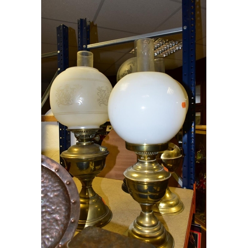 537 - FOUR BRASS BASED TWIN BURNER OIL LAMPS, one with a blue glass hand painted reservoir, the column mou... 