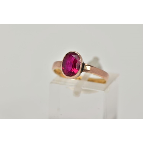 8 - A VICTORIAN YELLOW METAL RING, collet mounted oval cut synthetic ruby,  plain polished band, rubbed ... 