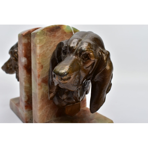 60A - A PAIR OF EARLY 20TH CENTURY FRENCH ALABASTER BOOKENDS mounted with a bronzed springer spaniel on on... 