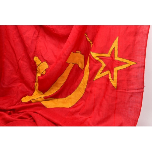 62 - A LARGE RED/GOLD COLOURED RUSSIAN (CCCP) FLAG, approximately six feet x eight feet, corded and bound... 